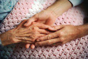 Senior woman's hands being held